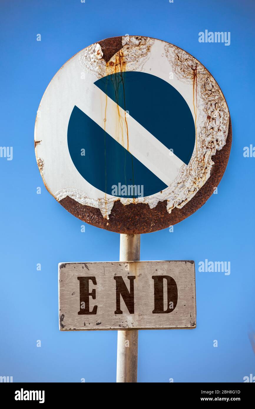 Straßenschild Verbot Zugang, am unteren Rand ein Schild mit dem Wort Ende. Im Hintergrund ein blauer Himmel. Das Straßenschild scheint durch das Wetter beschädigt und r Stockfoto