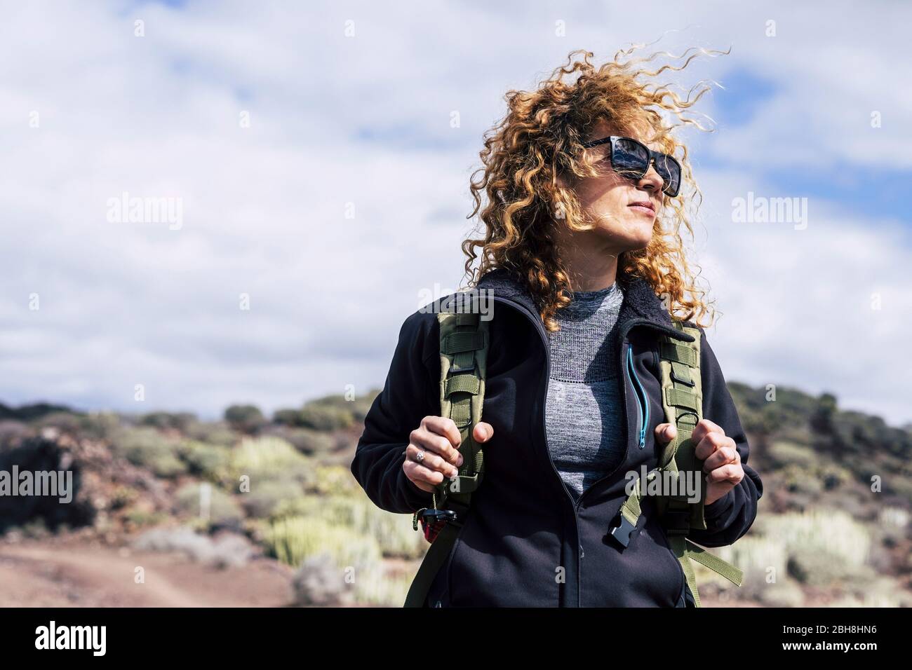Schöne lockige Haare mittleren Alters kaukasische Frau mit Rucksack in Trekking Aktivität im Freien - weibliche Wanderer auf dem Berg suchen - blauer Himmel Hintergrund und alternative Urlaubskonzept Stockfoto Schöne lockige Haare mittleren Alters kaukasische Frau mit Rucksack in Trekking Aktivität im Freien - weibliche Wanderer auf dem Berg suchen - blauer Himmel Hintergrund und alternative Urlaubskonzept Stockfoto