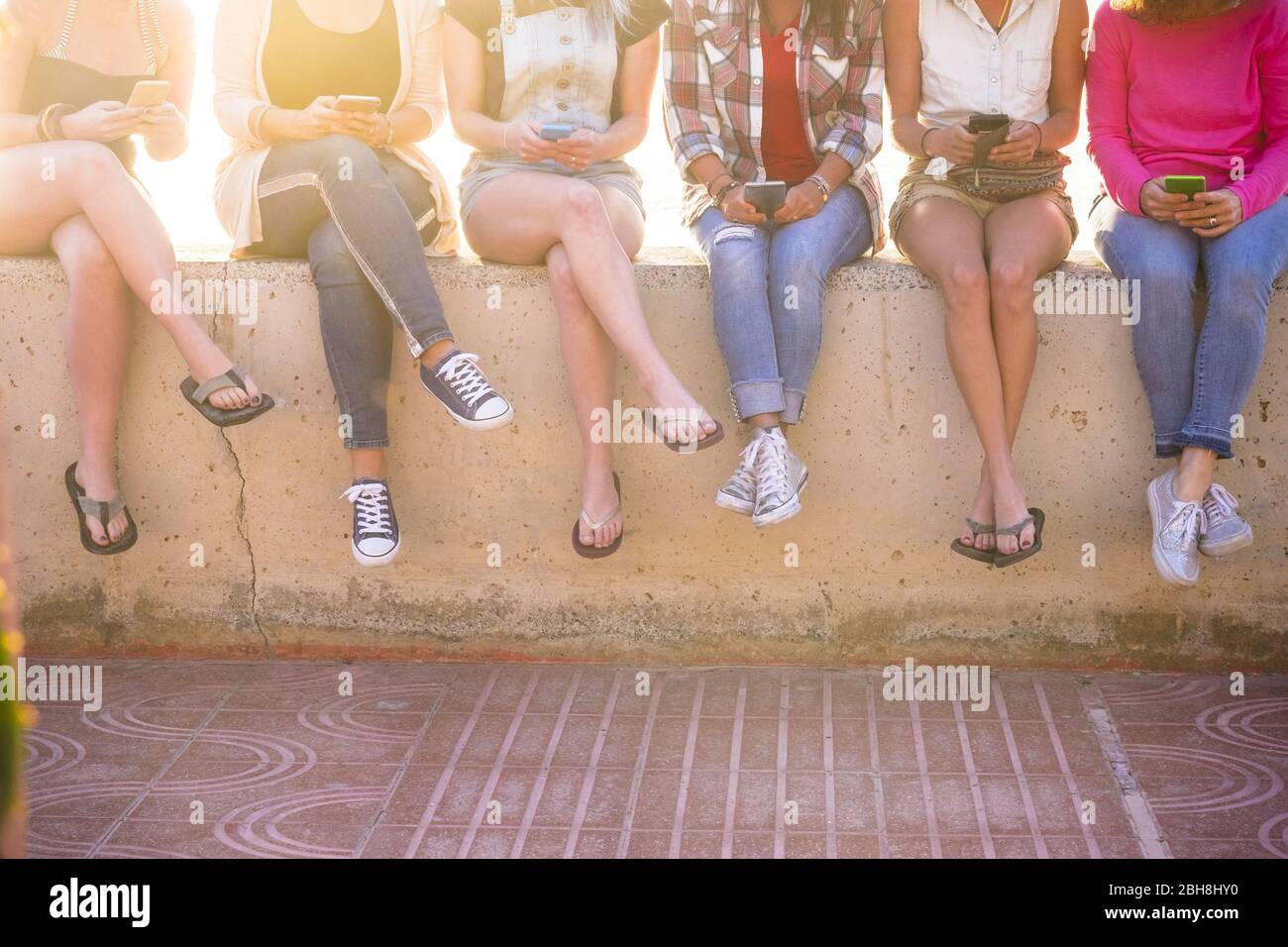 Gruppe von jungen Frauen in Freundschaft zusammen mit Cellula-Telefon-Technologie im Sommer mit Sonne im Hintergrund - Millennial und Internet Social Media süchtig Menschen Konzept - sechs Mädchen und Web-Gerät Stockfoto