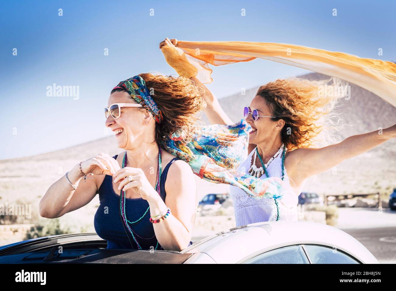 Paar mittleren Alters kaukasische Frau fröhlich und lachen genießen die Reise und den Urlaub mit Cabrio und spielen mit dem Wind für Freiheit Lifestyle-Konzept Stockfoto Paar mittleren Alters kaukasische Frau fröhlich und lachen genießen die Reise und den Urlaub mit Cabrio und spielen mit dem Wind für Freiheit Lifestyle-Konzept Stockfoto