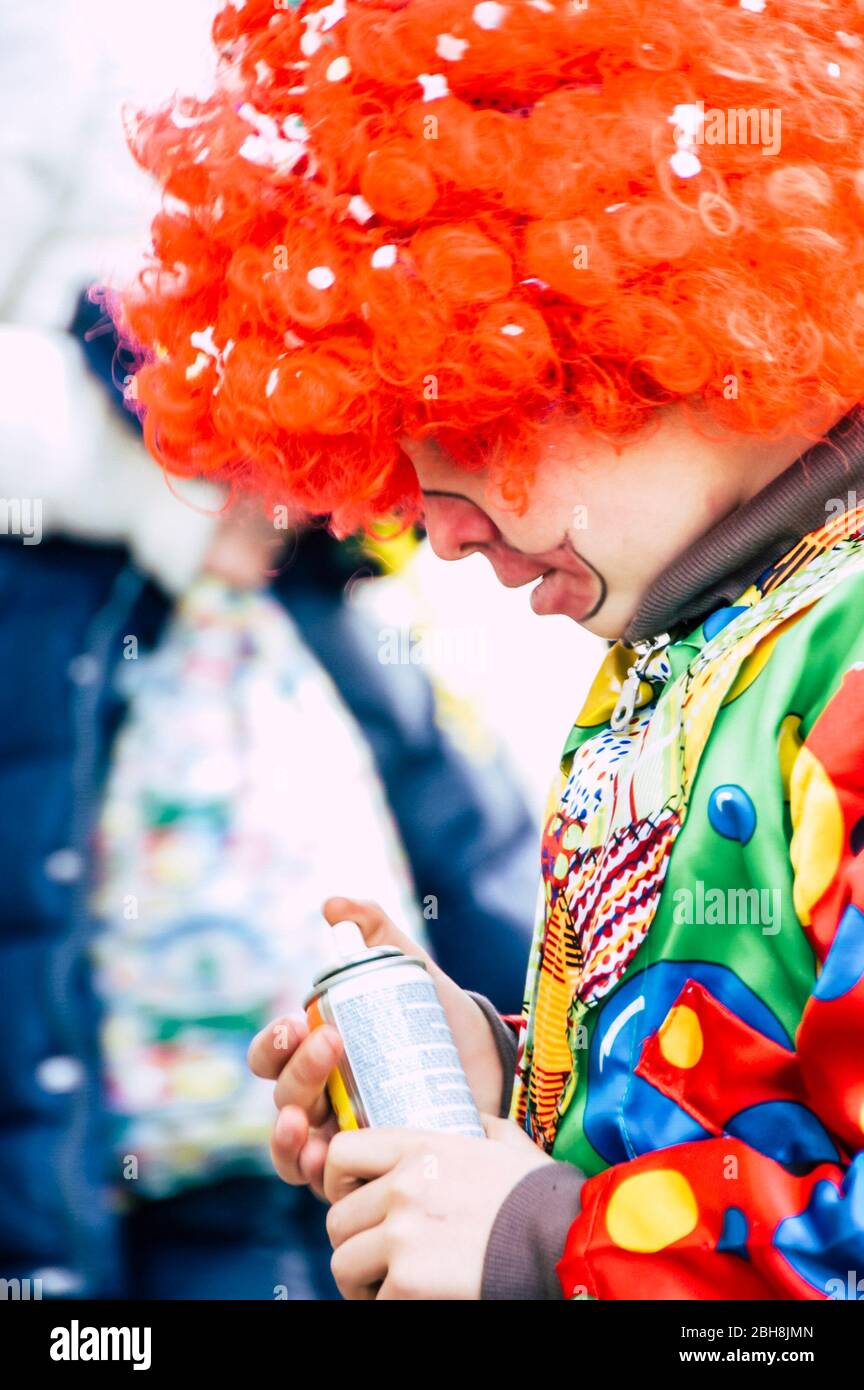 Junge Kinder männlich auf der Suche nach einem Spray und haben Spaß an Karneval - furry masls und lächeln Ausdruck - Farben und Konfetti in die Zeit Stockfoto