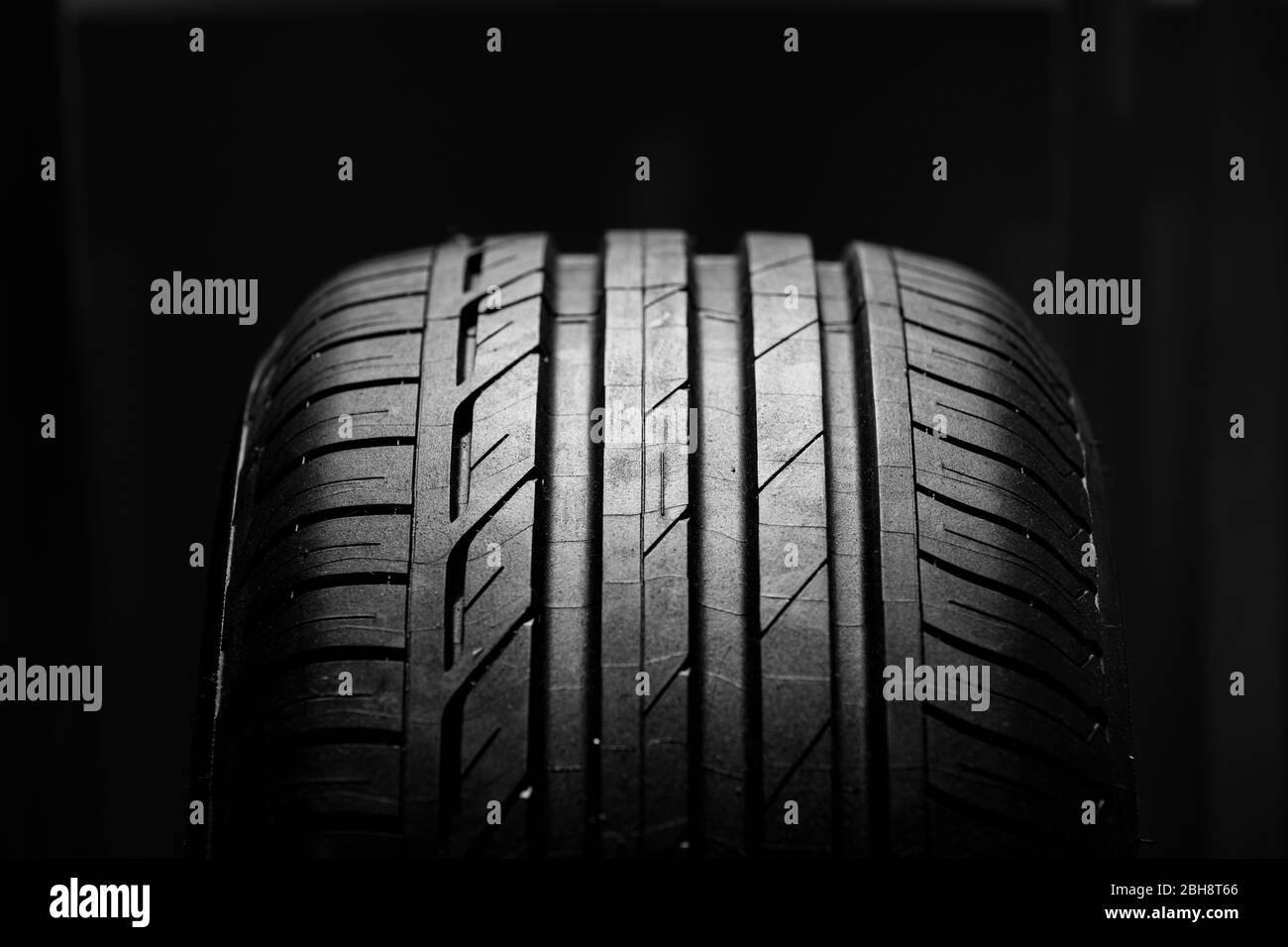 Studio-Aufnahme von brandneuen Autoreifen isoliert auf schwarzem Hintergrund. Nahaufnahme Stockfoto