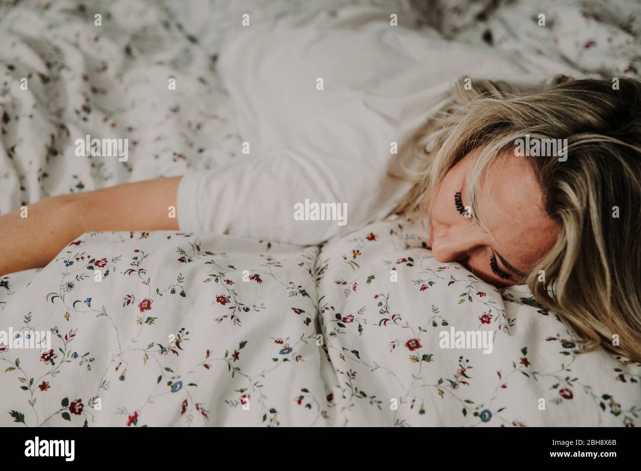 Frau liegt erschopft im Bett, Nahaufnahme Stockfoto