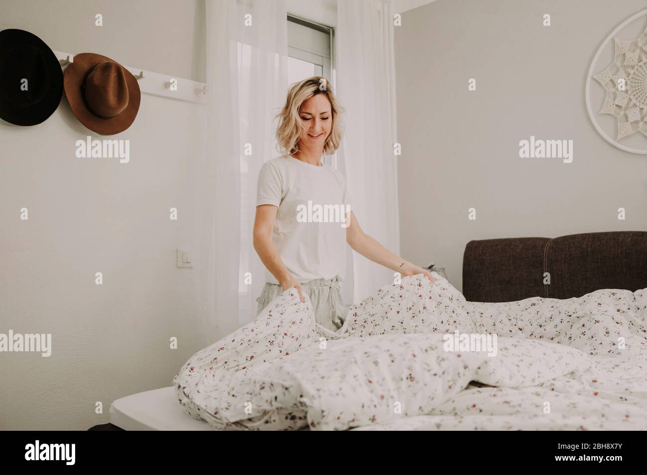 Frau, die Betten macht Stockfoto