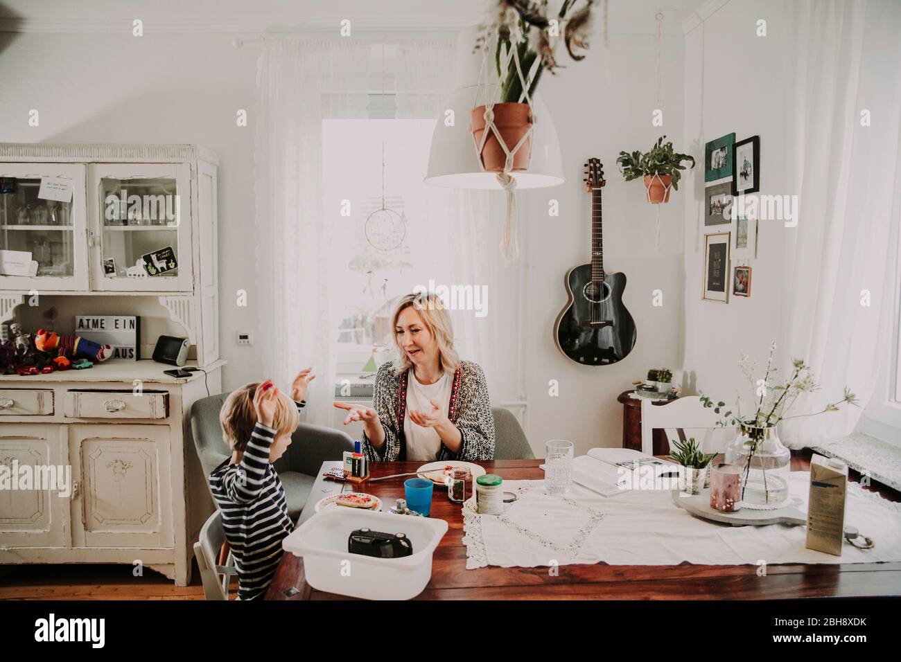 Mutter und Sohn sitzen gemeinsam am Frühstückstisch Stockfoto