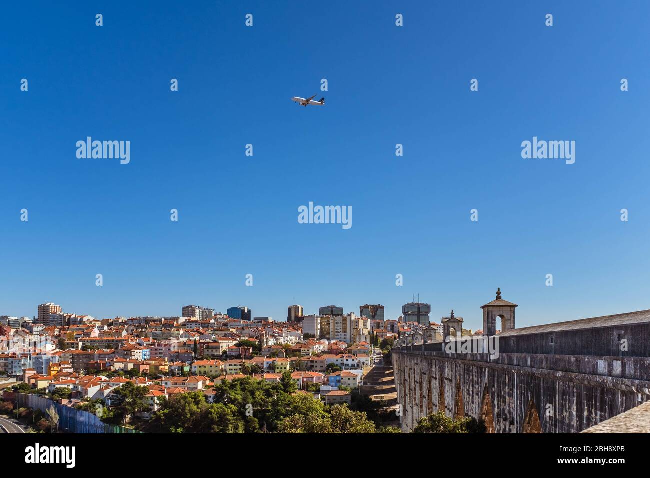 Flugzeug über Águas Livres Aquädukt mit Stadtbild auf einem Hintergrund, horizontale Ausbeschneiung. Stockfoto