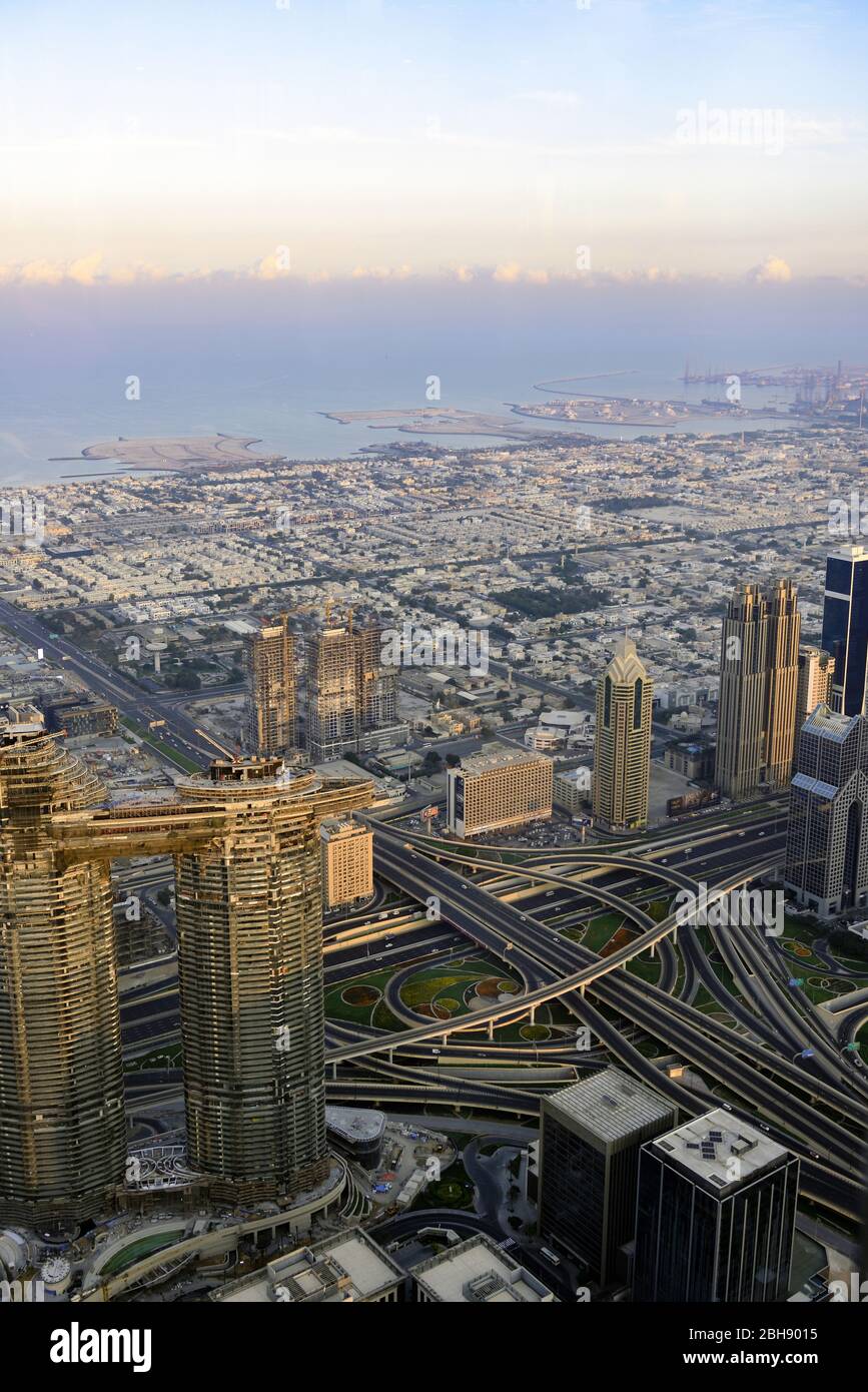 Dubai Downtown von oben, gesehen von der Aussichtsplattform des höchsten Hauses der Welt, dem Burj Khalifa bei Sonnenaufgang mit Kreuzung der Sheikh Zayed Road als wichtigste Schnellstraße Dubais Stockfoto