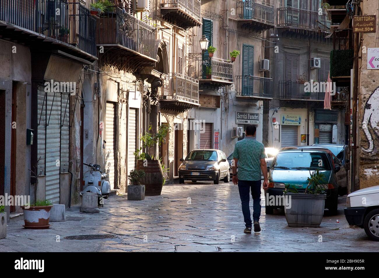 Palermo, Altstadt, Seitengasse, Balkone, geparkte Autos, Mann geht die Straße hinunter, Morgenlicht Stockfoto