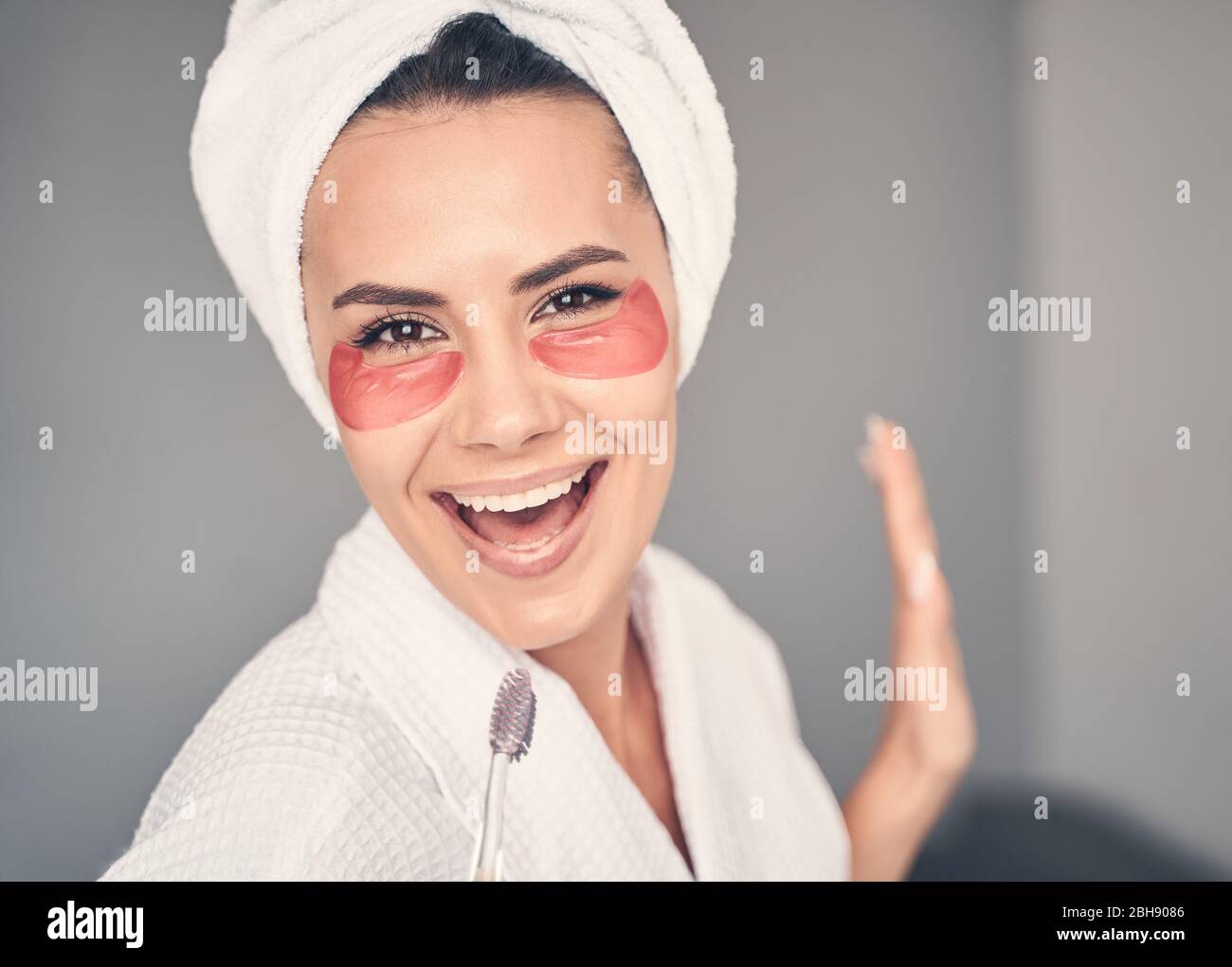 Fröhliches Mädchen mit einer Zahnbürste, die eine Melodie singt Stockfoto