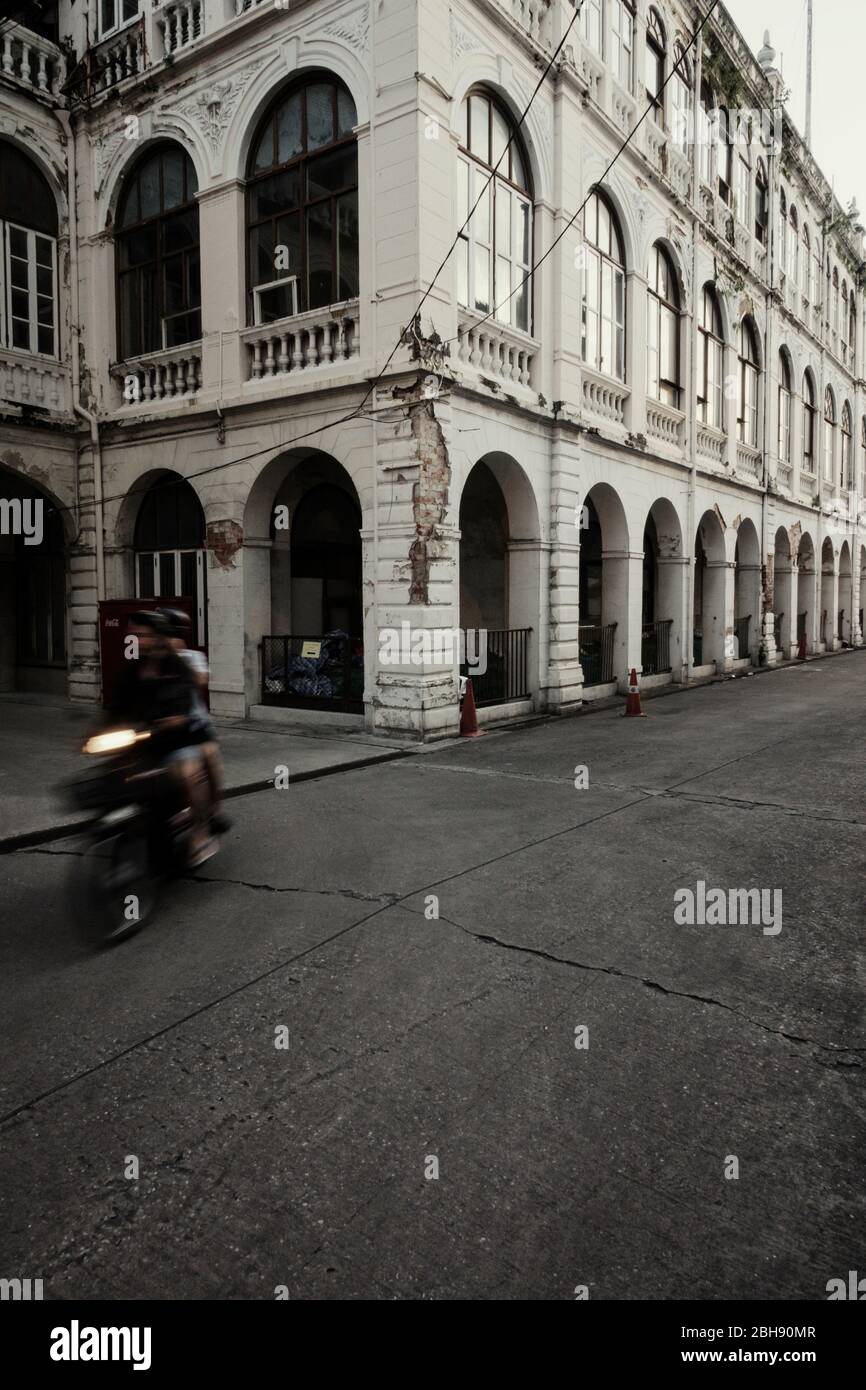 Gegend um das Oriental Hotel mit alten Kolonialgebäuden und Moped Riders Stockfoto