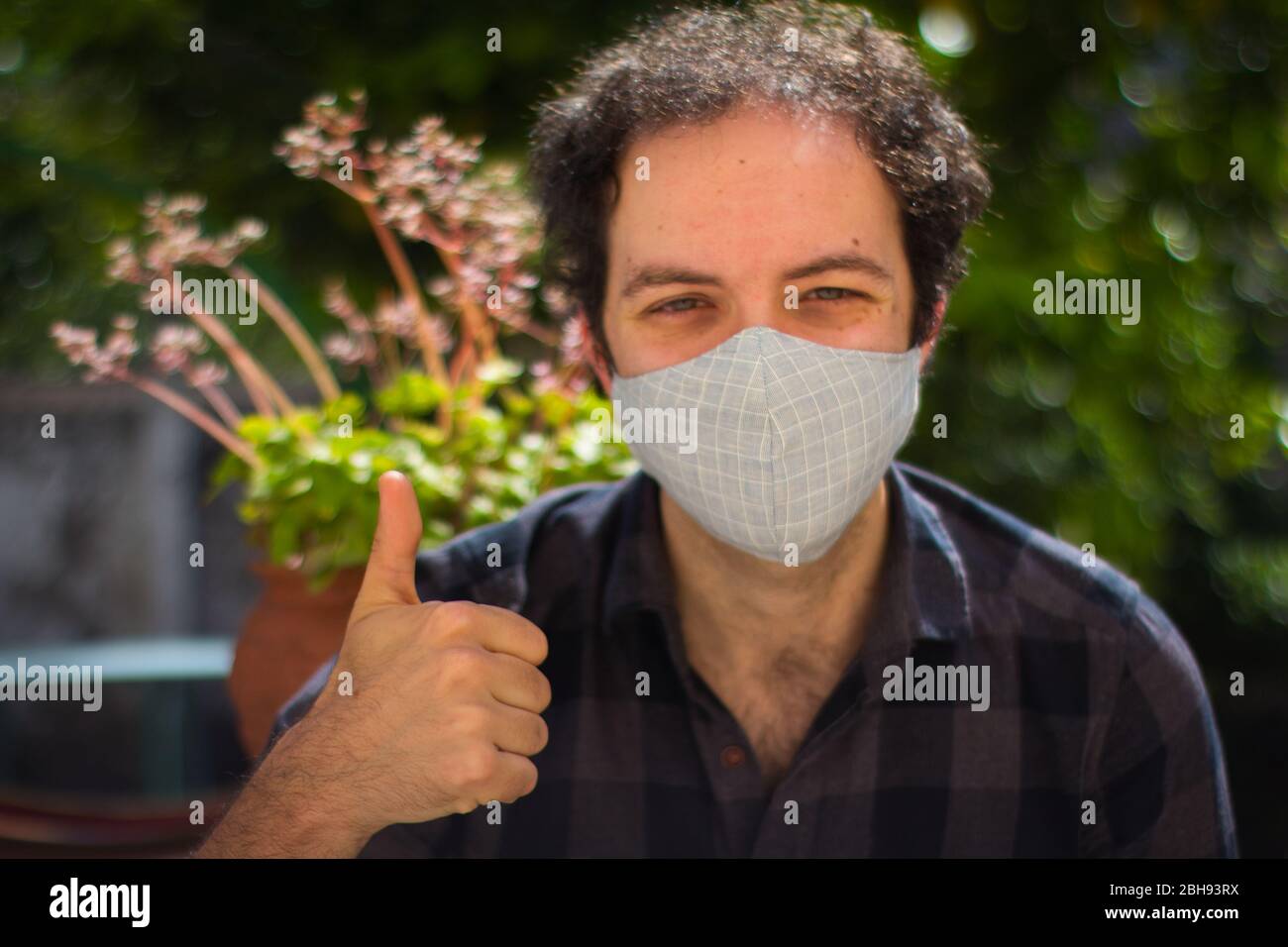 Junger Mann mit einer Präventionsmaske, die das Schild 'ok' macht Stockfoto