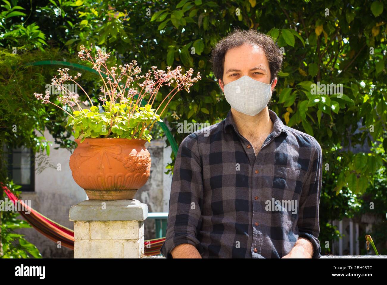 Junger Mann mit Maske im Garten Stockfoto