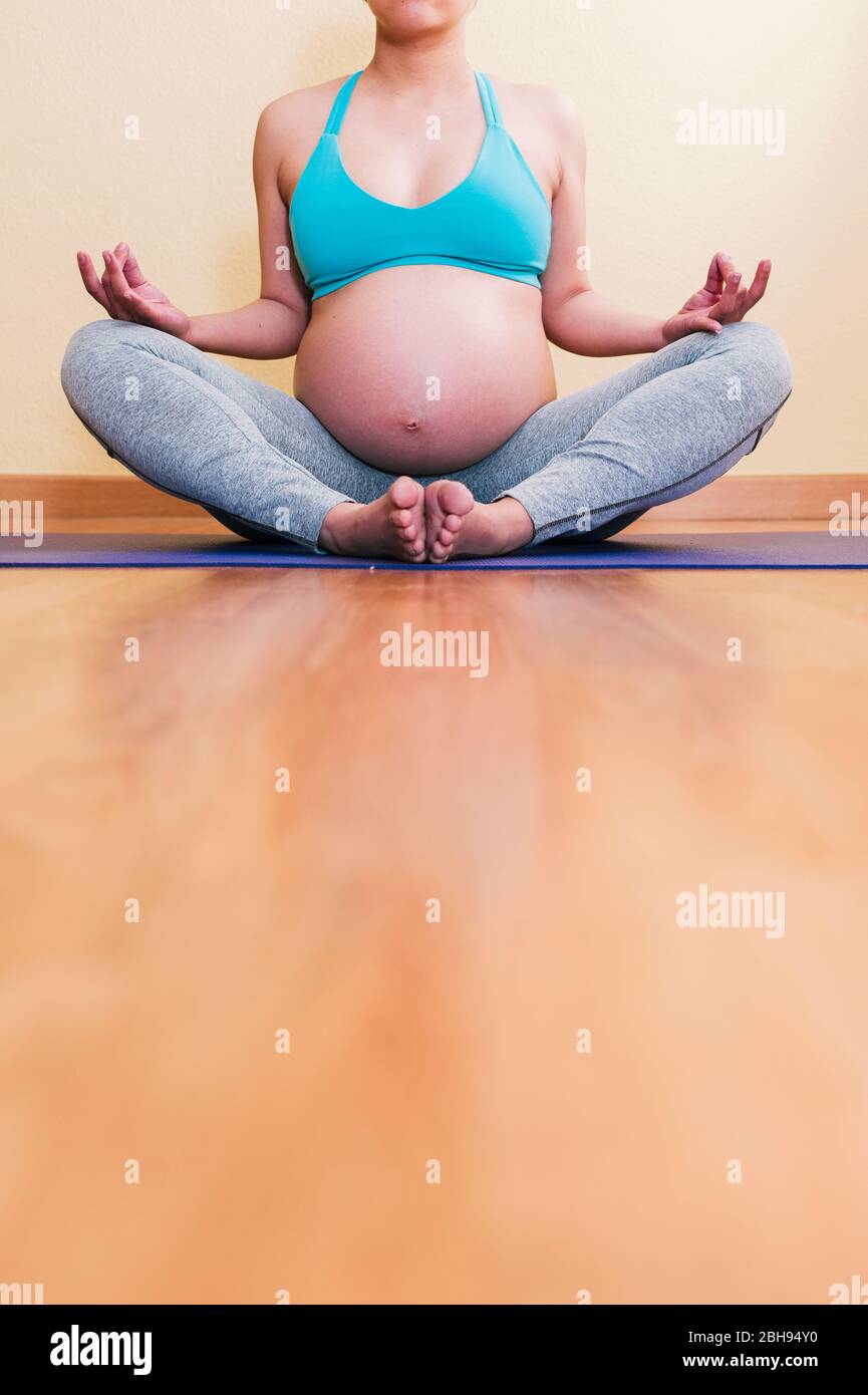 Asiatisch schwanger Yoga auf einer Yoga Pose auf einem violetten Yoga Matte Stockfoto