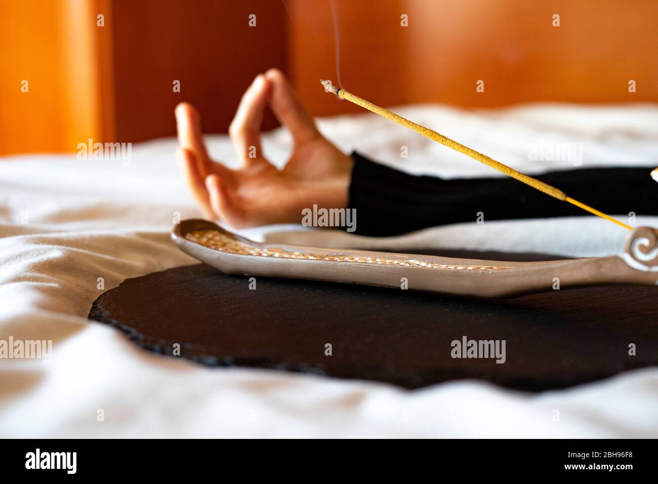 Räucherstäbchen bei einer Yoga-Session beleuchtet. Stockfoto