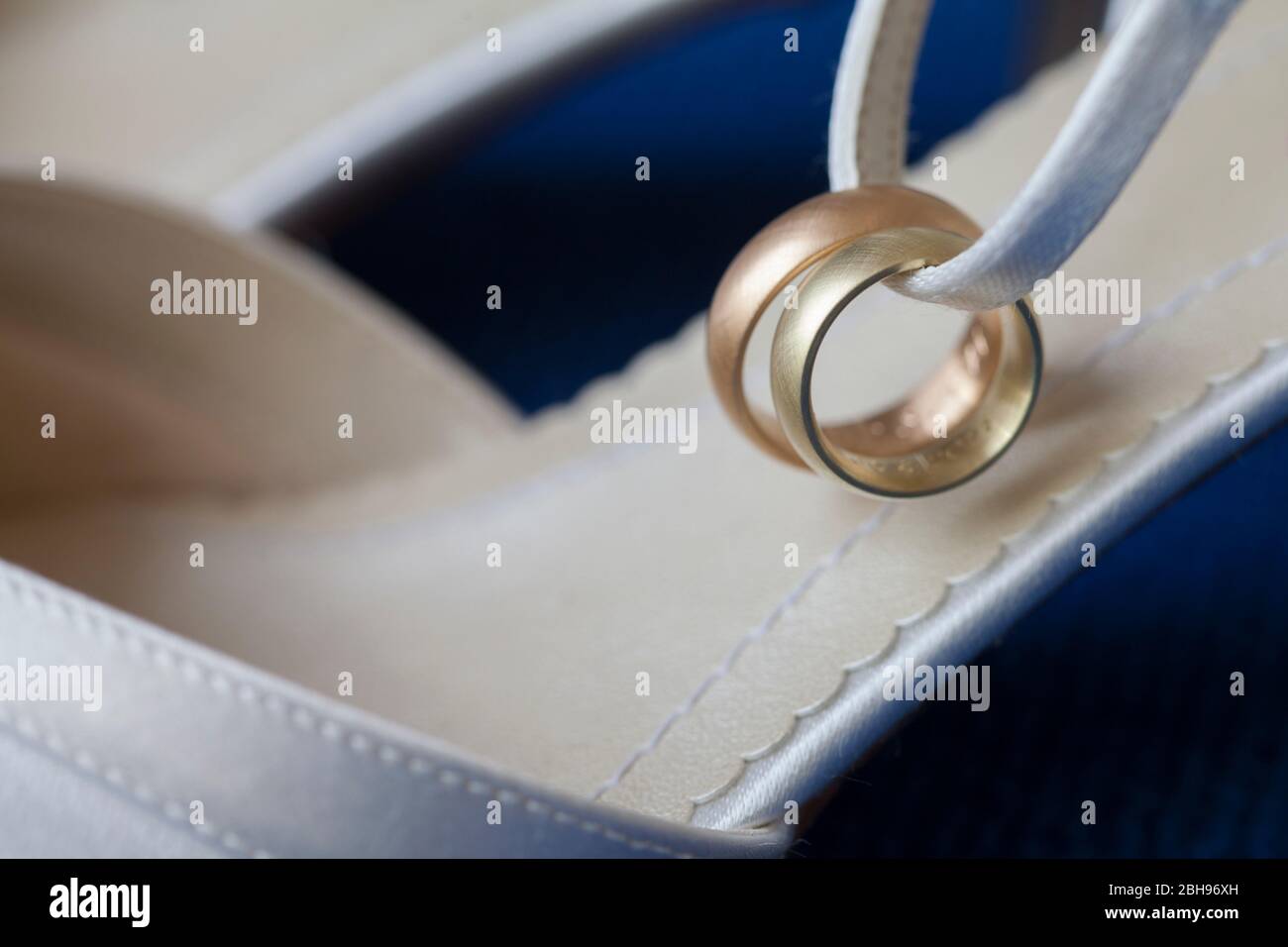 Hochzeitsringe aus Gold und Rotgold am weißen Brautschuh Stockfoto