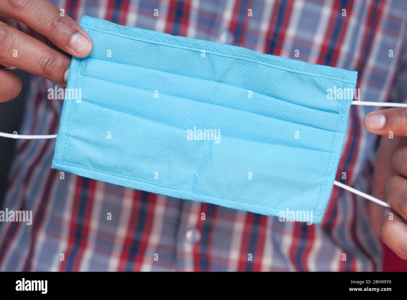 Mann Hand hält chirurgische Maske, Nahaufnahme. Stockfoto