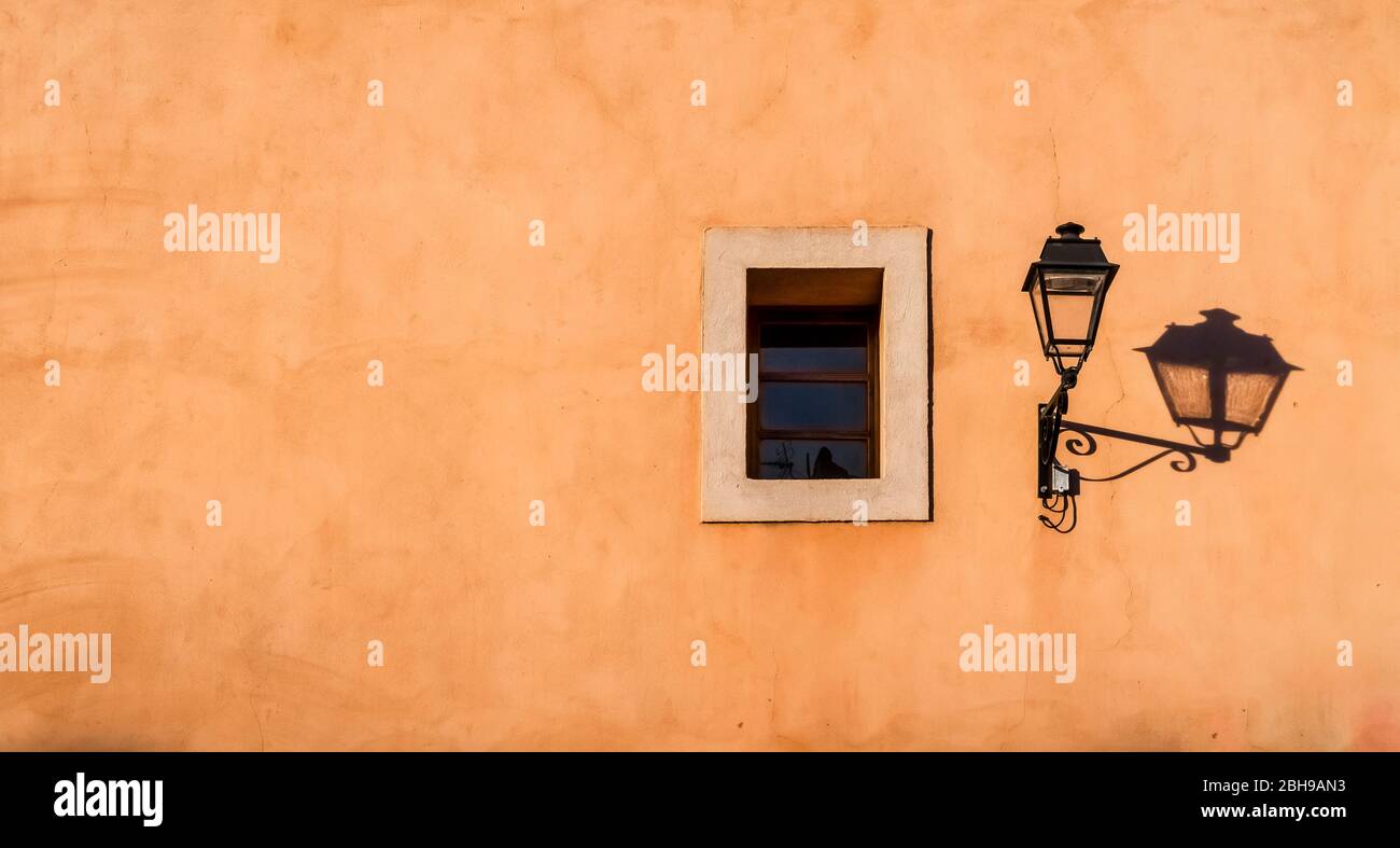 Alte Straßenlampe und Fenster mit Schatten in Coursan Stockfoto