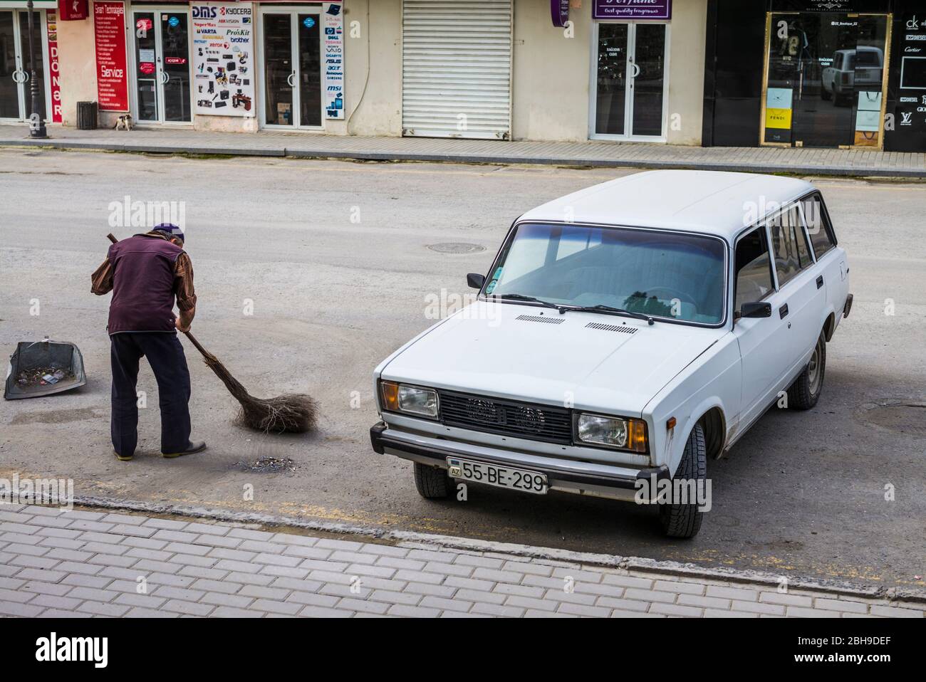 Aserbaidschan, Sheki, Straßenfeger, keine Freigaben, mit Schiguli-Auto aus der Sowjetzeit Stockfoto