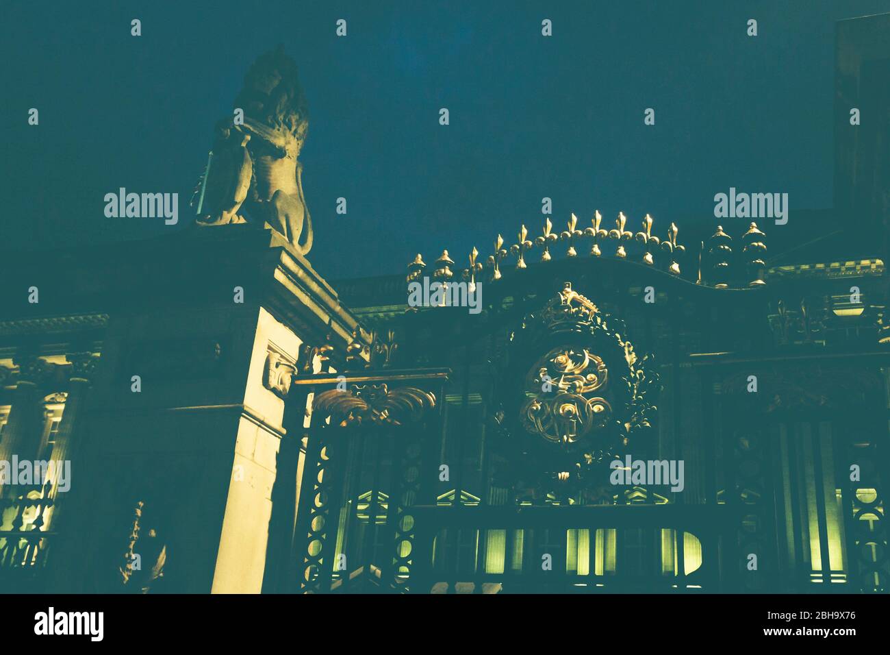 Ein Löwe und das vergoldete Symbol am Eingangstor zum Buckingham Palace, Sitz der Monarchie und königlichen Familie in London, England, Großbritannien. Stockfoto