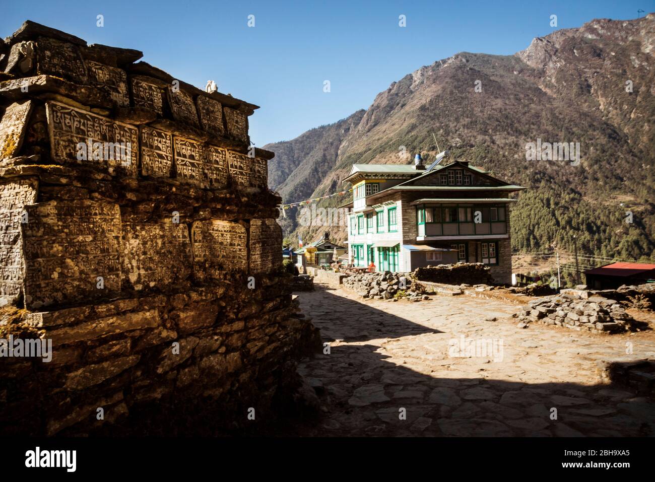Gebetstische mit Wohnhaus auf dem Weg Stockfoto