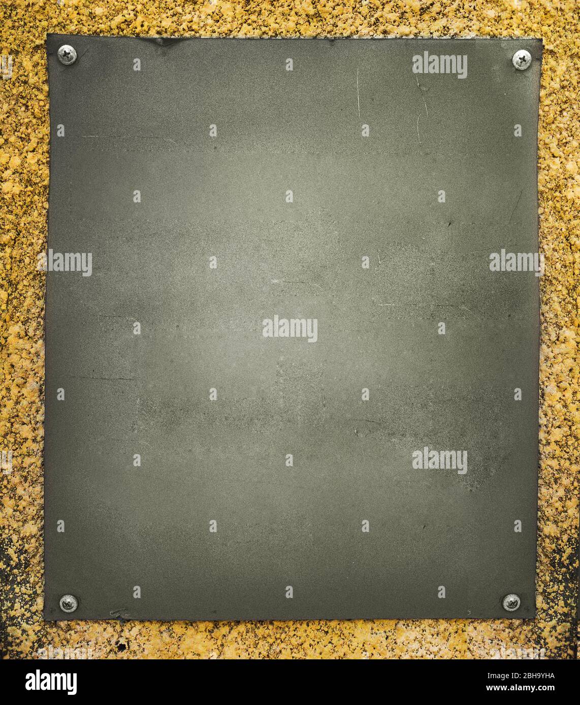 Alte geschraubte Plakette an der Steinwand Stockfoto
