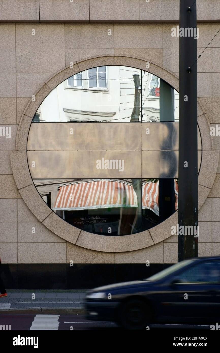 Eine kreisförmige Dekoration Spiegel an der Außenfassade eines Gebäudes mit Durchgangsverkehr. Stockfoto