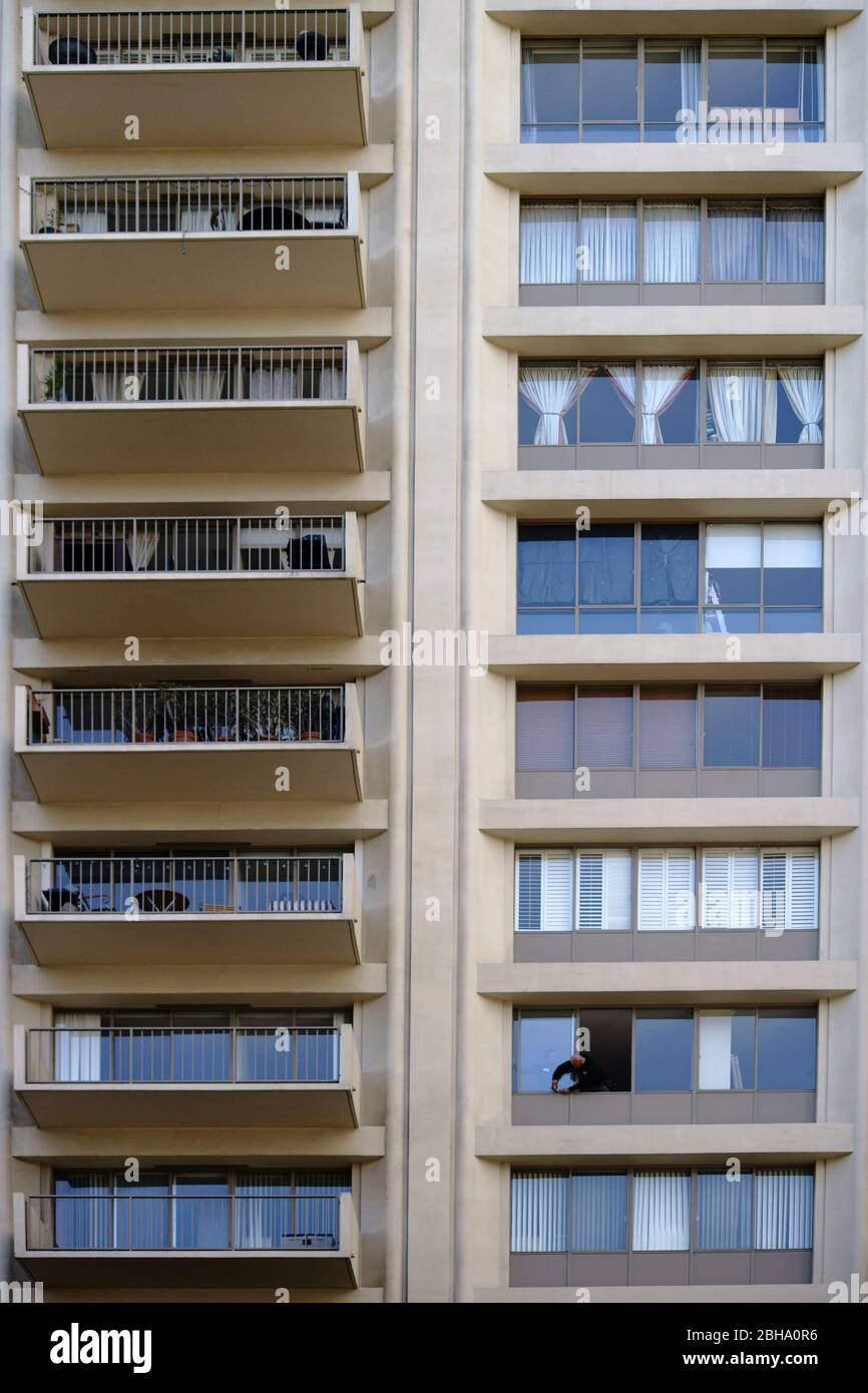 Ein Hausmeister repariert das Fenster einer Wohnung in einem Hochhaus in Los Angeles. Stockfoto