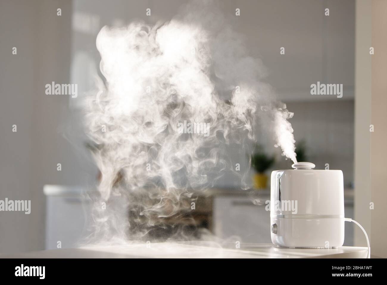 Nahaufnahme des Aromaöldiffusors auf dem Tisch zu Hause, Dampf aus dem Luftbefeuchter. Ultraschalltechnologie, Erhöhung der Luftfeuchtigkeit im Innenbereich, beruhigender Einsatz Stockfoto