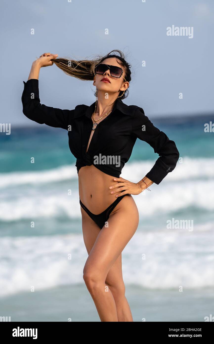 Ziemlich junges hispanischer Model, das eine gute Zeit am Strand am Meer hat. Stockfoto