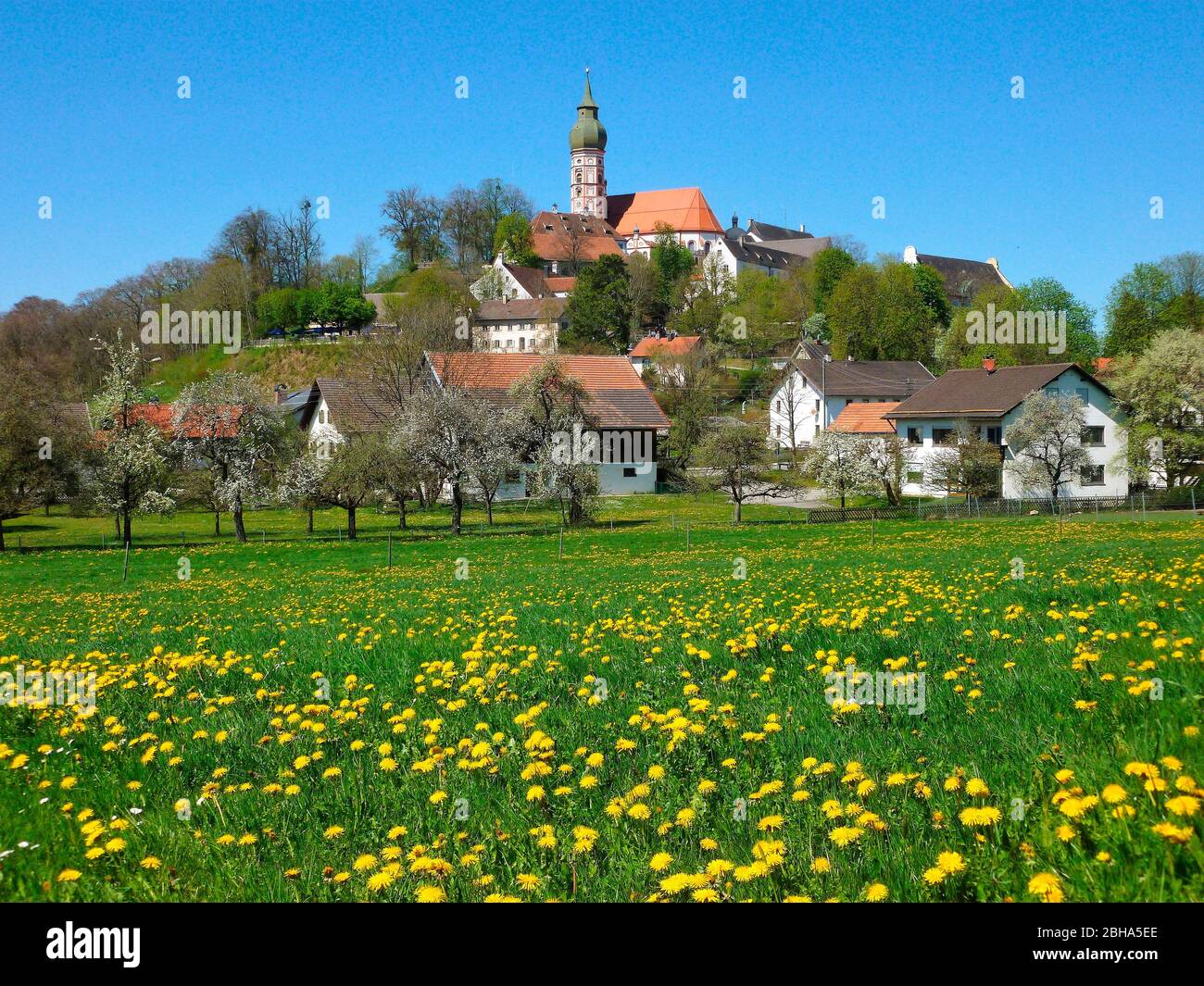 Deutschland, Oberbayern, Andechs, Wohnhäuser und Klosterkirche im Frühjahr Stockfoto