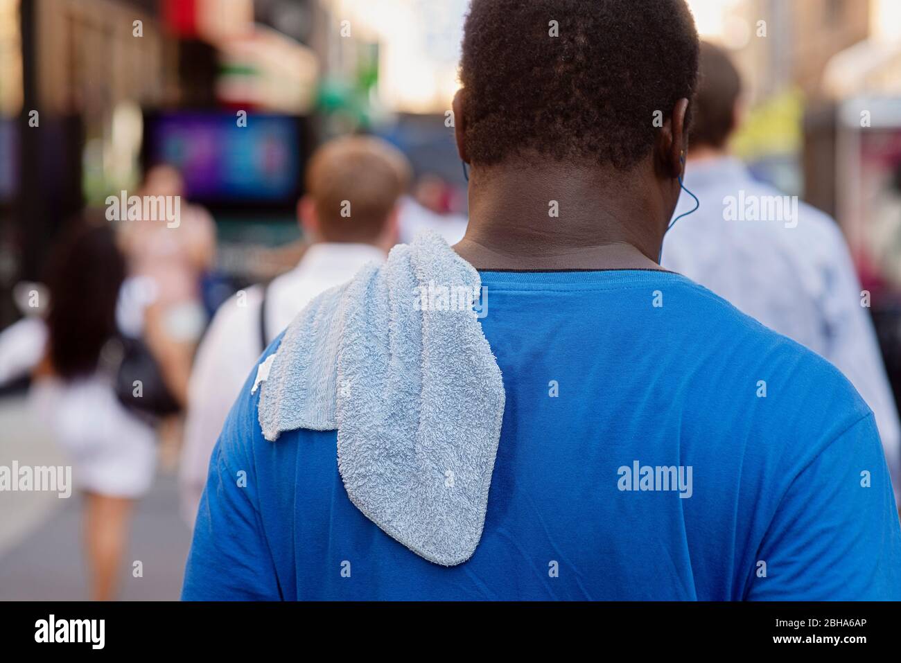 Ein verschwitzter Mann, der im Juli eine New Yorker Straße entlang läuft. Stockfoto