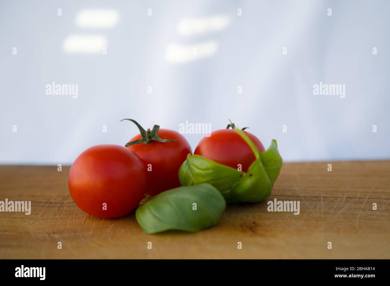 Tomaten und Basilikum auf einem weißen Tisch Zutaten für eine echte Pizza Stockfoto
