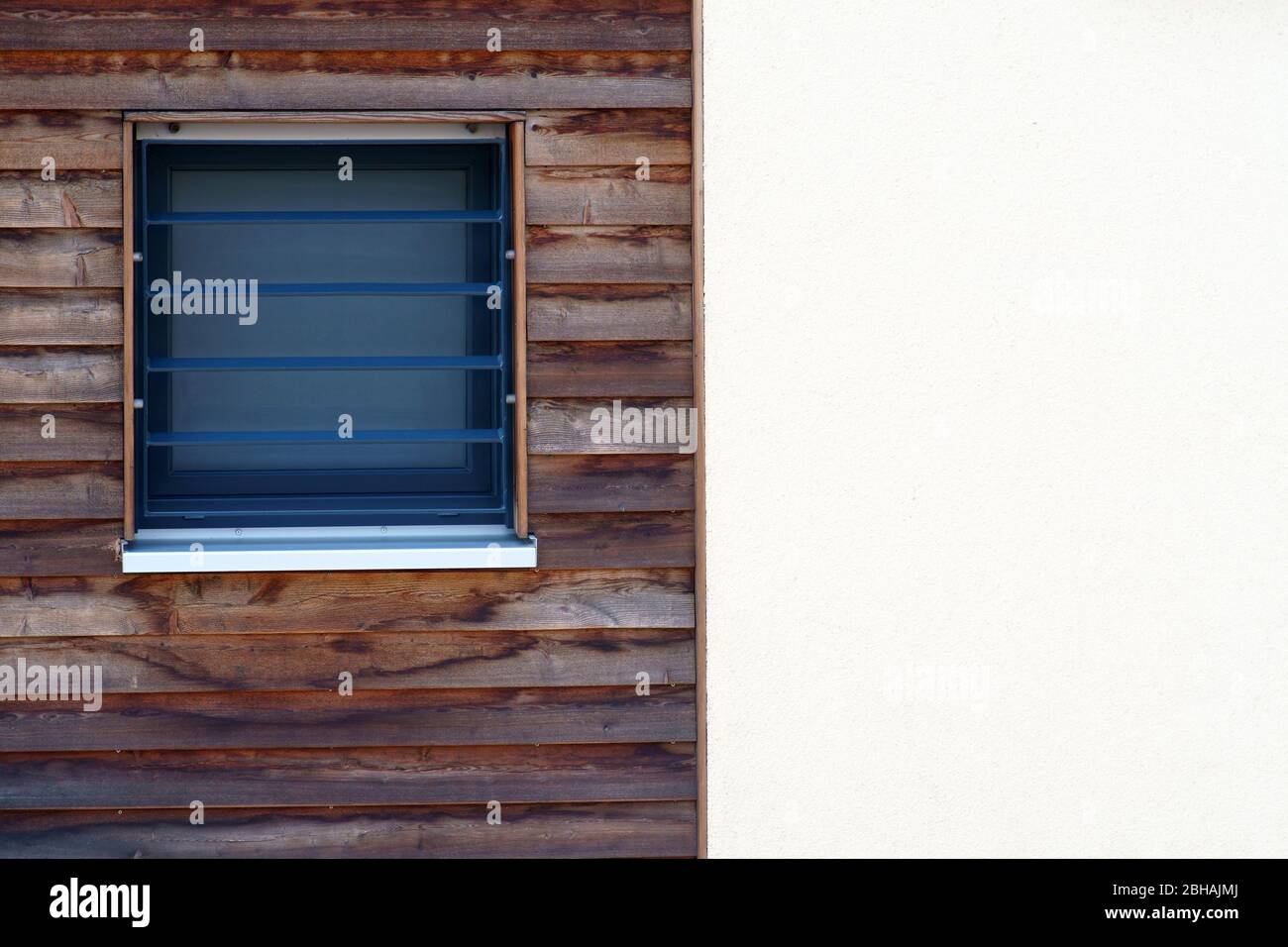 Der Außenfassade eines Wohnhauses mit einem kleinen Fenster in der Holztäfelung. Stockfoto Der Außenfassade eines Wohnhauses mit einem kleinen Fenster in der Holztäfelung. Stockfoto