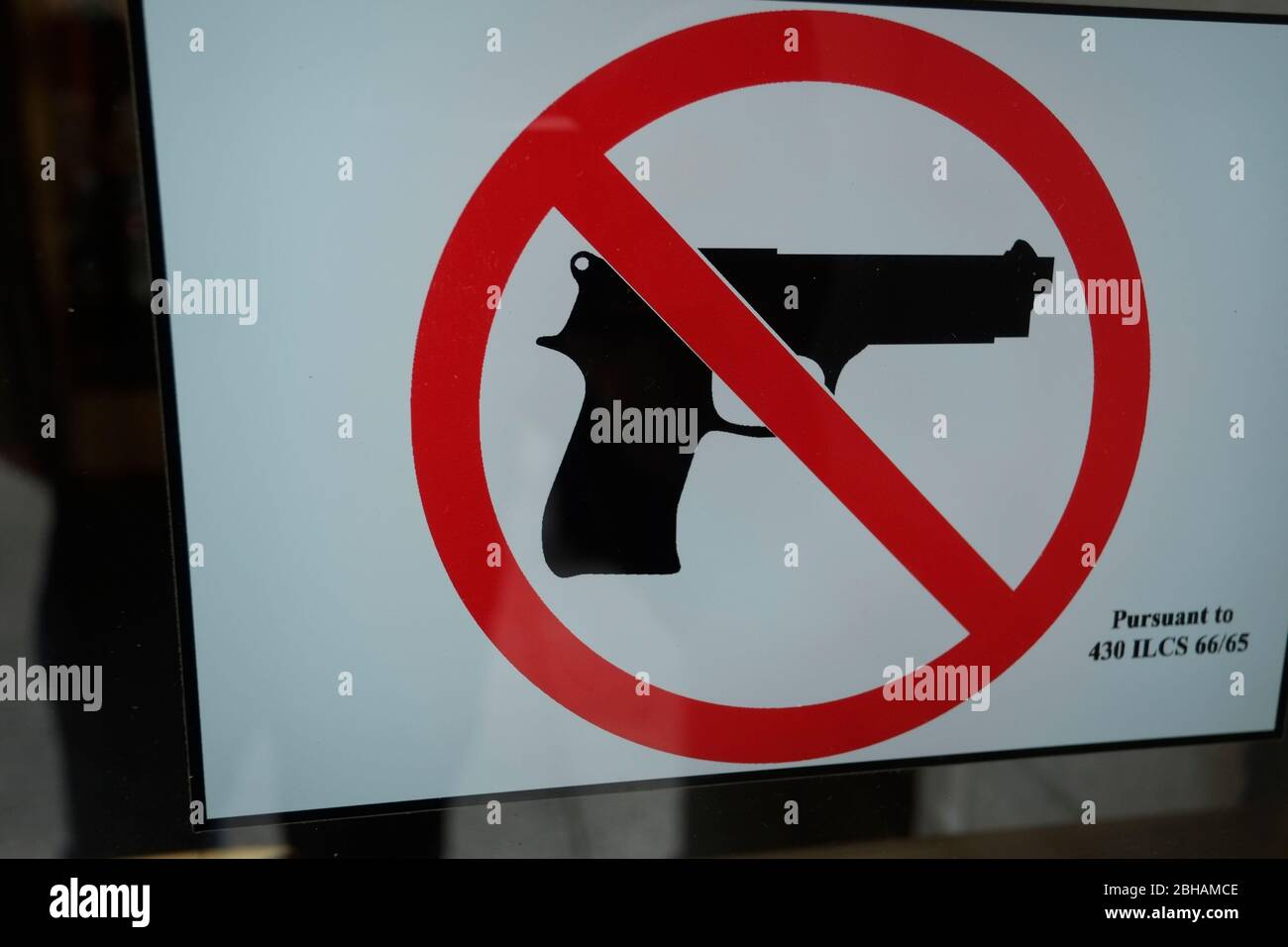 Das Schild der gekreuzten Schusswaffe an der Tür der Bank verbietet den Zugang mit Waffen Stockfoto