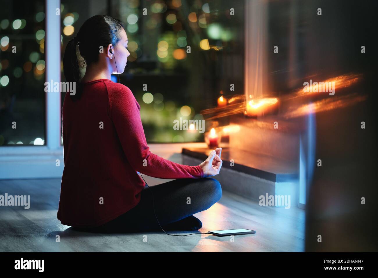 Frau Meditiert Nachts Mit Smartphone App Für Yoga Stockfoto