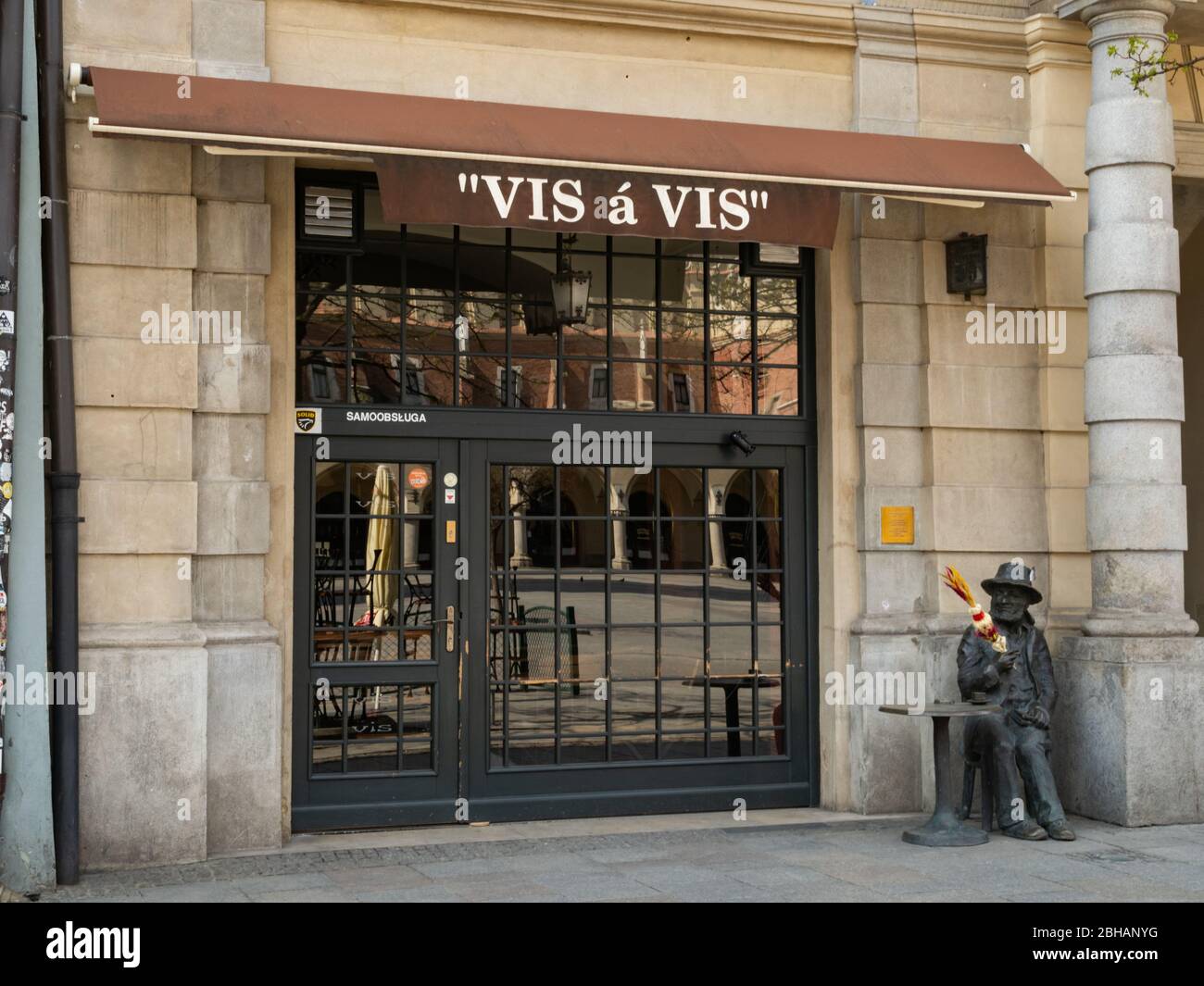Krakau/Polen - 22/04/2020. Fast leerer Hauptplatz in Krakau während der Coronavirus Covid-19 Pandemie. Blick über das geschlossene Restaurant und die Statue von Skrzyn Stockfoto