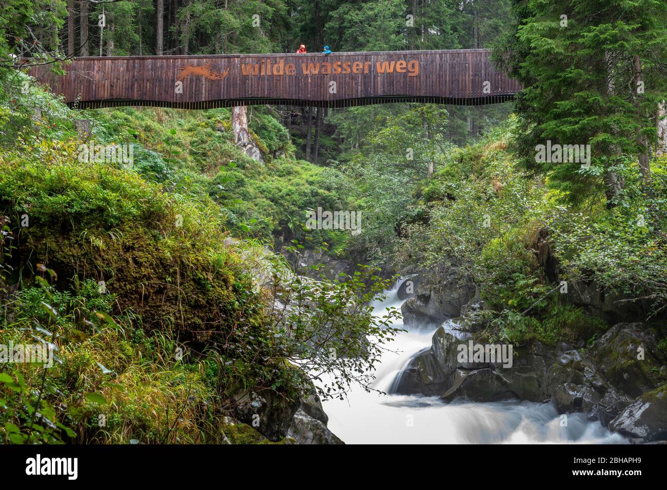 Europa, Österreich, Tirol, Neustift im Stubaital stehen Mutter und Sohn auf einer Holzbrücke und blicken auf den Ruetz hinunter Stockfoto