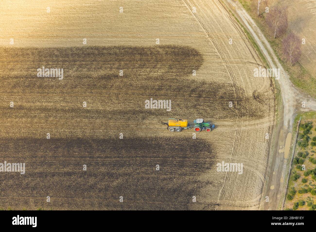 Luftaufnahme des Düngersprühens mit Traktor auf Feldern, Enkdorf, Meschede, Nordrhein-Westfalen, Deutschland Stockfoto