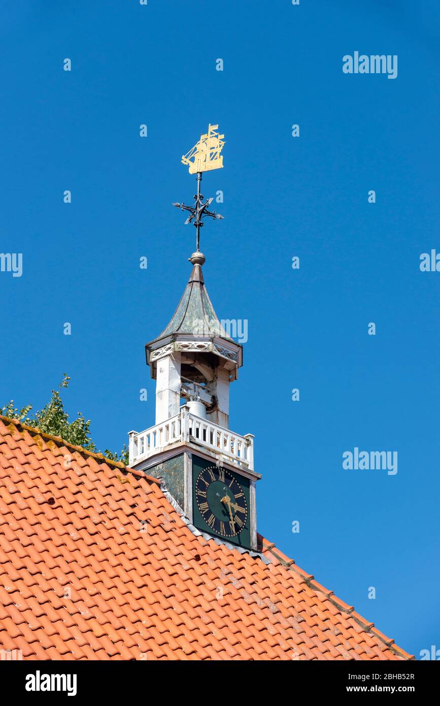 Deutschland, Niedersachsen, Ostfriesland, Greetsiel, Dachrücken der evangelisch-reformierten Kirche, die Wetterfahne von 1730 in Form eines Schiffes. Stockfoto