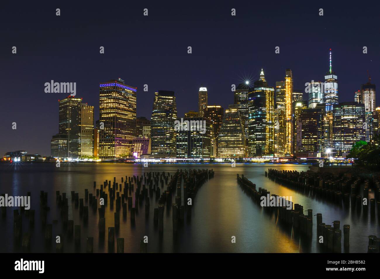 Blick über den Eastriver auf die Silhouette von Downtown Manhattan als lange Sicht in der Nacht Stockfoto