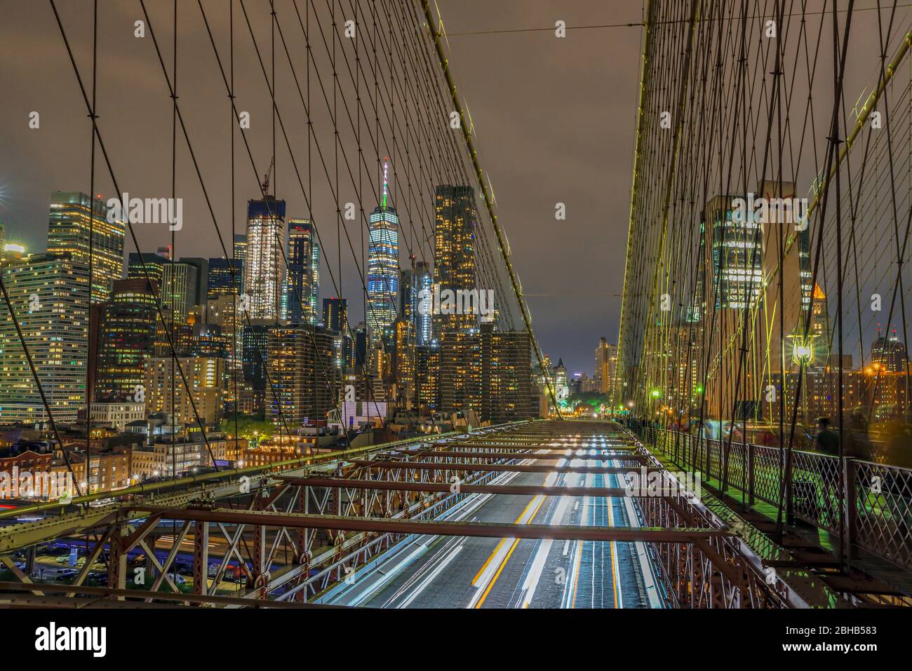 Blick über die Brooklyn Bridge mit der beleuchteten Silhouette der Wolkenkratzer in Downtown Manhattan für die Nacht Stockfoto