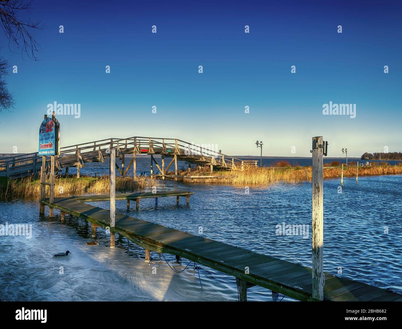 See mit einer kleinen Brücke und Steg in der Sonne Stockfoto