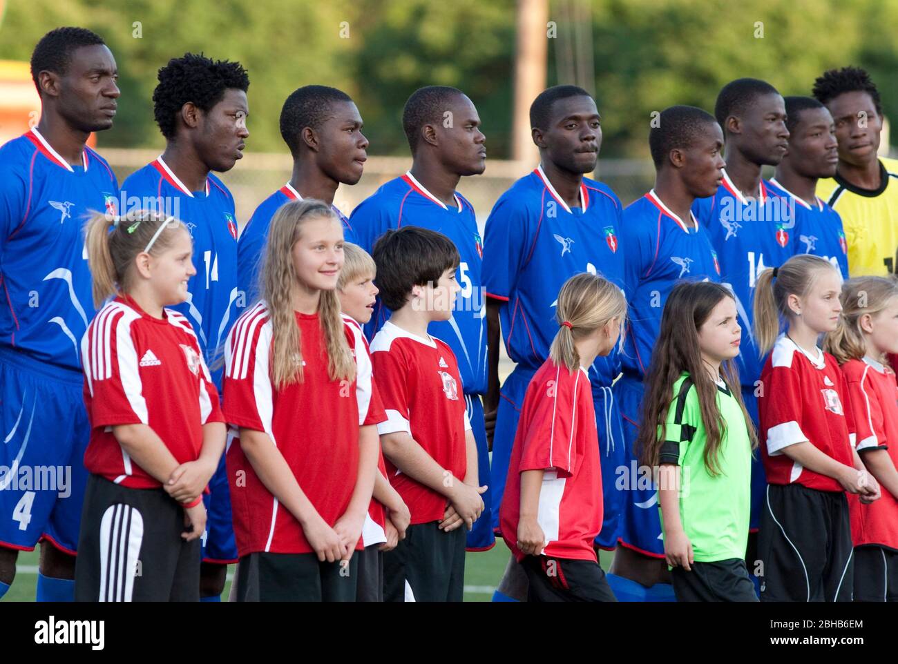 Austin, Texas USA, 28. April 2010: Schüler stehen mit Mitgliedern der haitianischen Fußballnationalmannschaft bei einem Ausstellungsspiel mit der professionellen Fußballmannschaft Austin Aztek. Das Haitianer-Werk in Port au Prince wurde durch das Erdbeben vom 12.. Januar dezimiert und 32 Teammitglieder wurden getötet. Die überlebenden Teammitglieder haben ein Angebot angenommen, für zwei Wochen in Texas zu trainieren und werden nächste Woche nach Argentinien reisen, um Südamerikanische Matchups zu machen. ©Bob Daemmrich Stockfoto