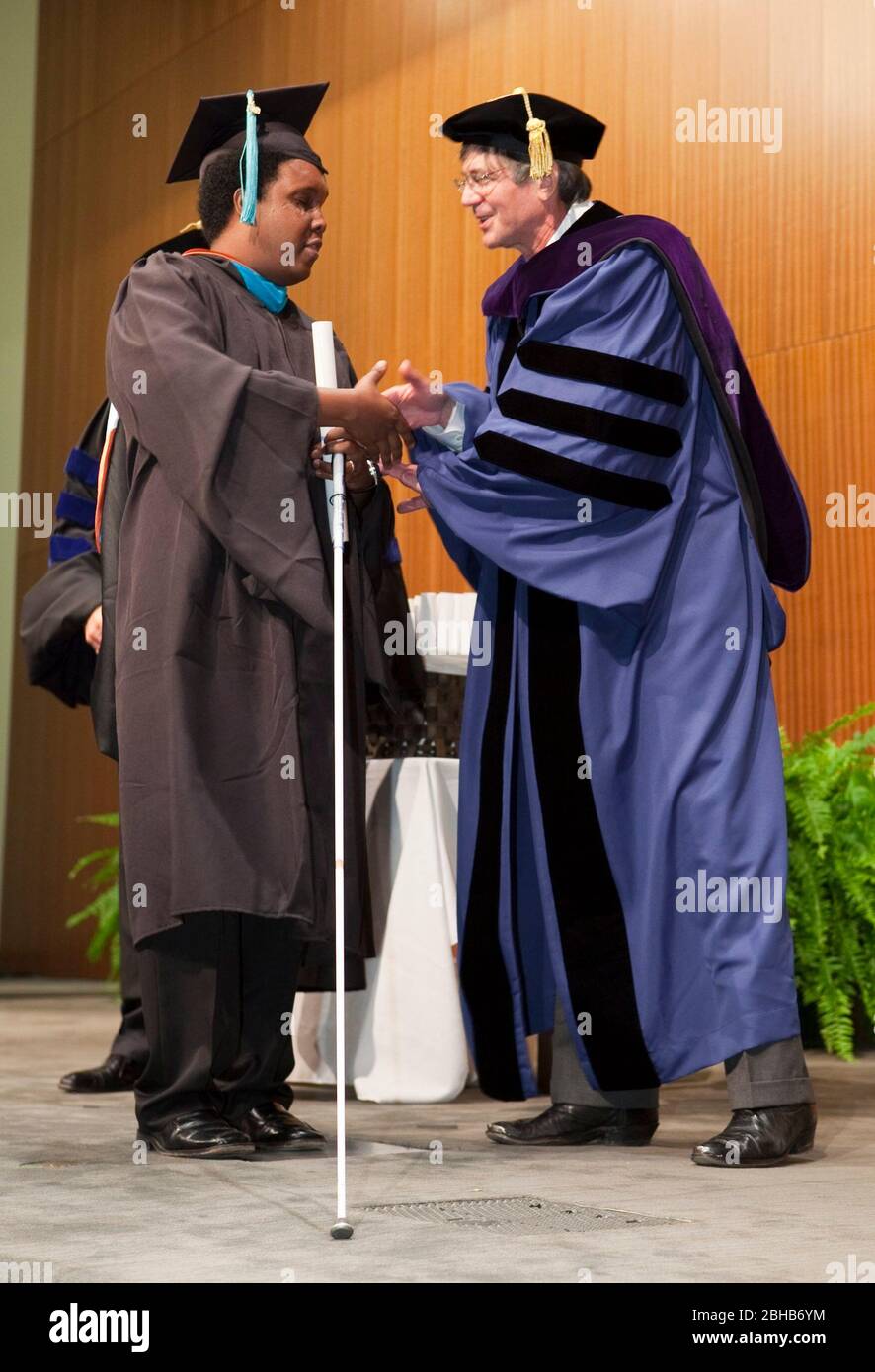 Austin , Texas - 22. Mai 2009 Ein blinder Student, der einen weißen Stock verwendet, nimmt an der Abschlussfeier an der Lyndon Baines Johnson (LBJ) School of Public Affairs Teil. Etwa 108 Studenten haben an der Universität von Texas in Austin ihren Master oder Doktortitel in Public Policy Studies erhalten. Keynote-Speaker James Steinberg (r) hilft bei der Aushänigung von Diplomen. ©Bob Daemmrich Stockfoto