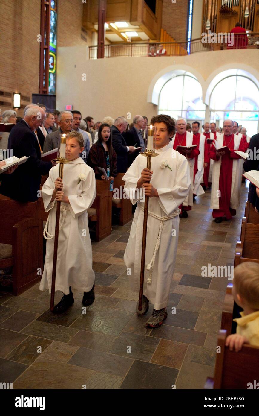 Austin, Texas, USA, April 4 2010: Jugendliche Alter Boys tragen weiße Alben und tragen Kerzen und führen die Prozession in das Heiligtum zum Ostersonntagsgottesdienst in der Lutherischen Kirche St. Martin. ©Bob Daemmrich Stockfoto