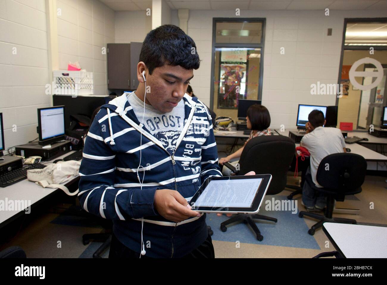 Manor Texas USA, Mai 12 2010: Teenager liest Text auf einem Apple iPad Tablet-Computer, während sie im Computerlabor der Manor New Tech High School, einer innovativen öffentlichen Schule, die sich auf projektbasiertes Lernen im Lehrplan TSTEM (Technology Science Engineering Mathematics) konzentriert. ©Bob Daemmrich Stockfoto