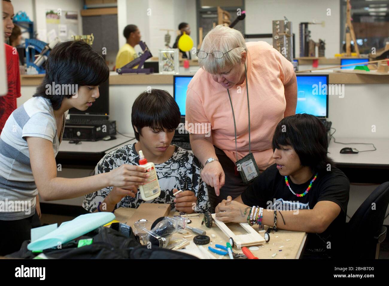 Manor Texas USA, Mai 12 2010: Die Wissenschaftlerin sieht sich an, wie Schüler gemeinsam an einem Modell-Solarauto arbeiten, als Teil eines Klassenprojekts an der Manor New Tech High School, einer innovativen öffentlichen Schule, die sich auf projektbasiertes Lernen im Lehrplan TSTEM (Technology Science Engineering Mathematics) konzentriert. ©Bob Daemmrich Stockfoto