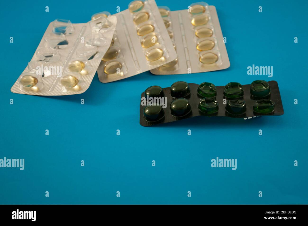 Blister von gelben Pillen, Vitamine, Tablette, Medizin auf blauem Hintergrund Stockfoto