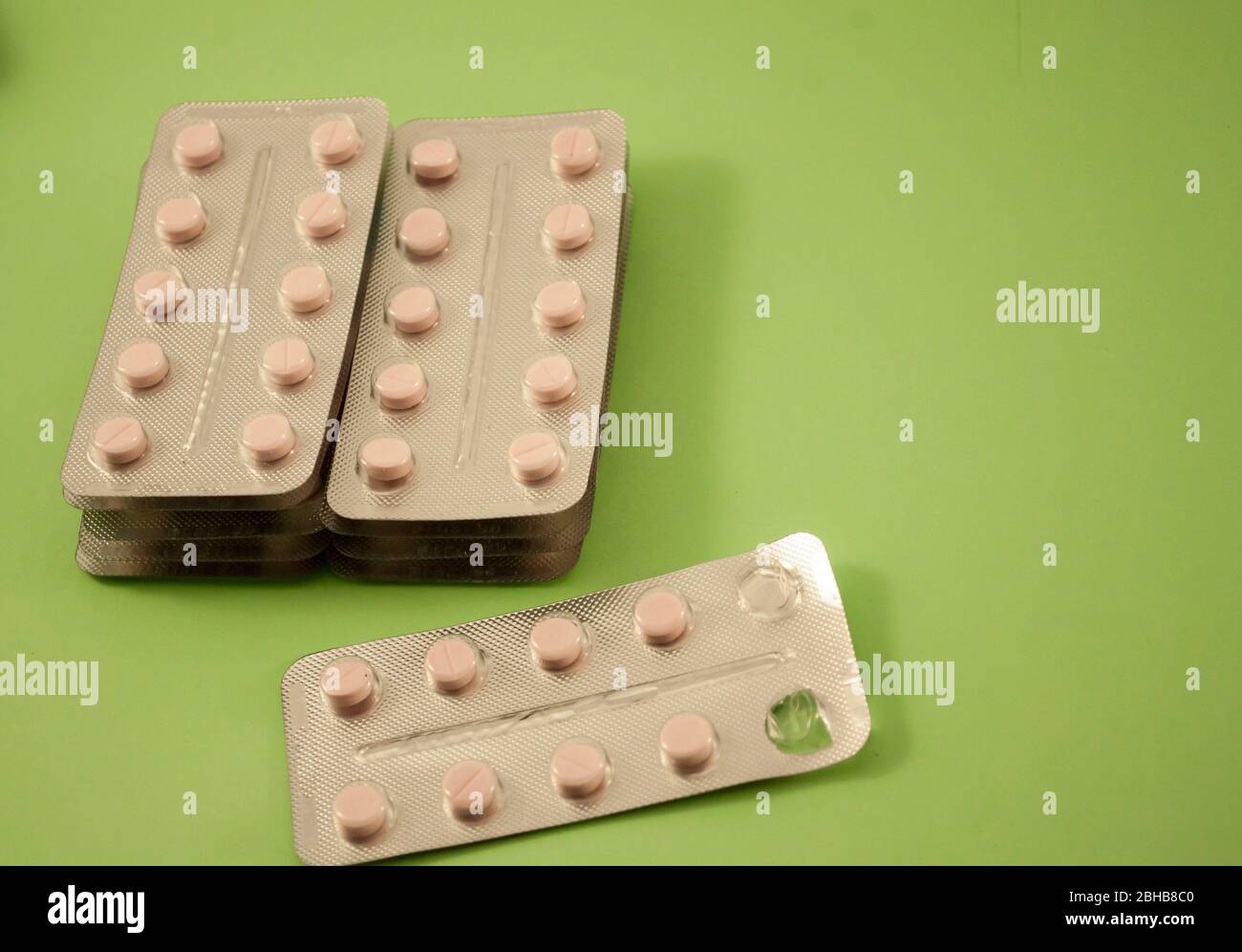 Blister von rosa Pillen, Vitamine, Tablette, Medizin auf grünem Hintergrund Stockfoto