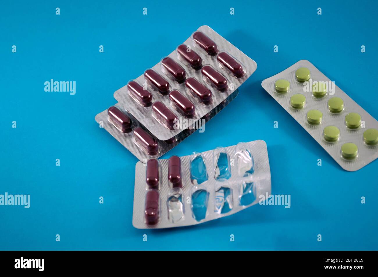 Blister mit Pillen, Vitaminen, Tablette, Medizin auf blauem Hintergrund, halb leer Stockfoto